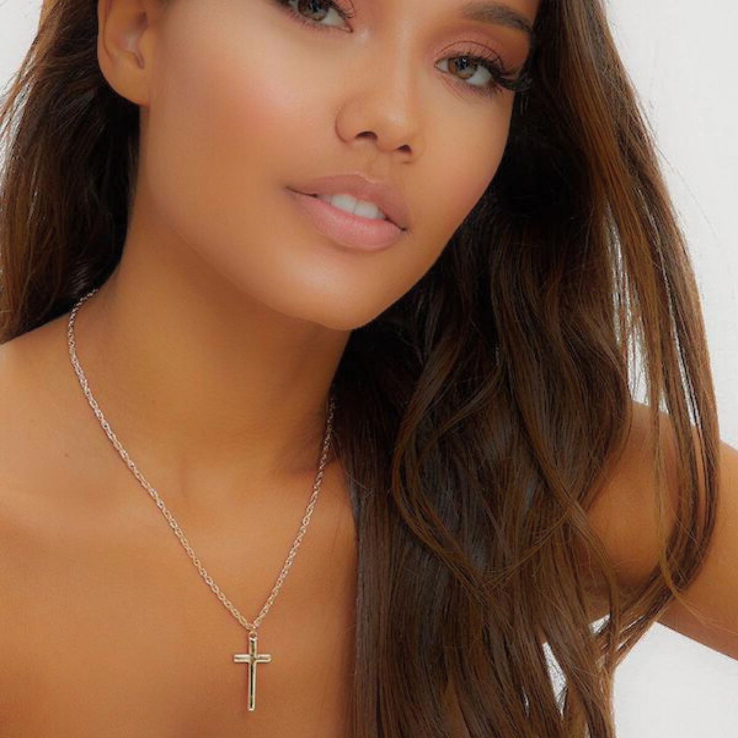 Lady wearing a Cross necklace looking at the camera. Promoting our Christian Necklace collection